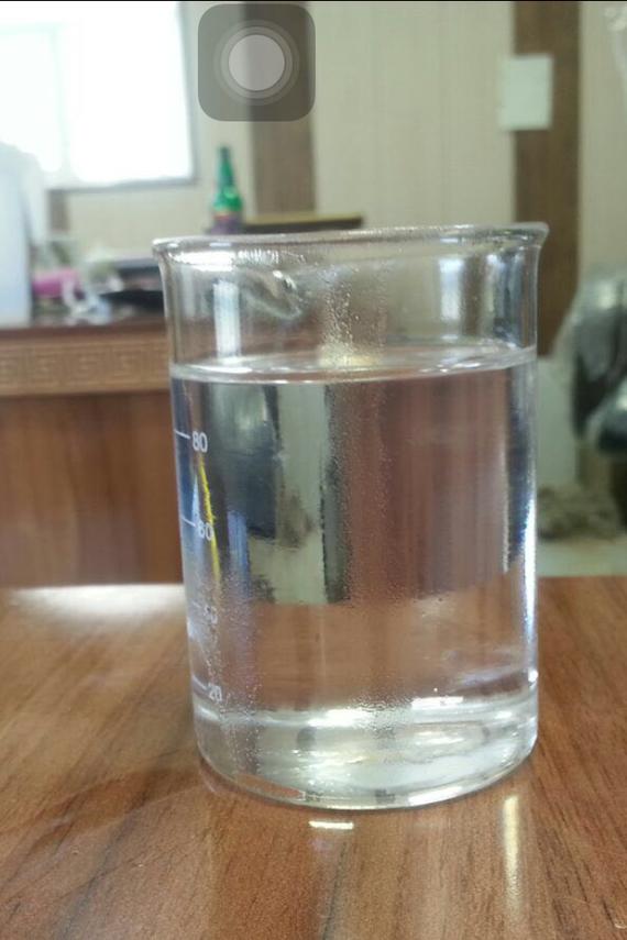 A glass of water is sitting on a wooden table.