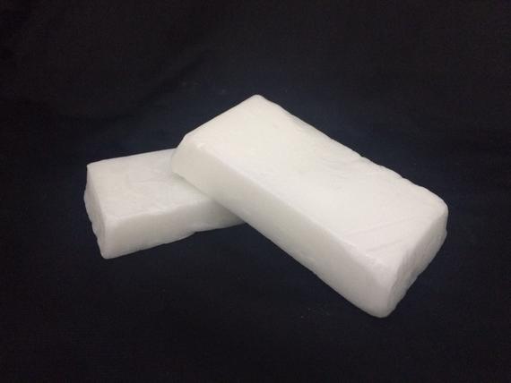 Two white blocks are stacked on top of each other on a black surface