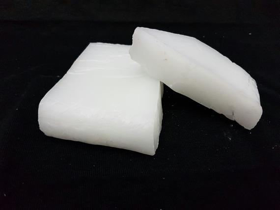 Two pieces of white wax on a black surface