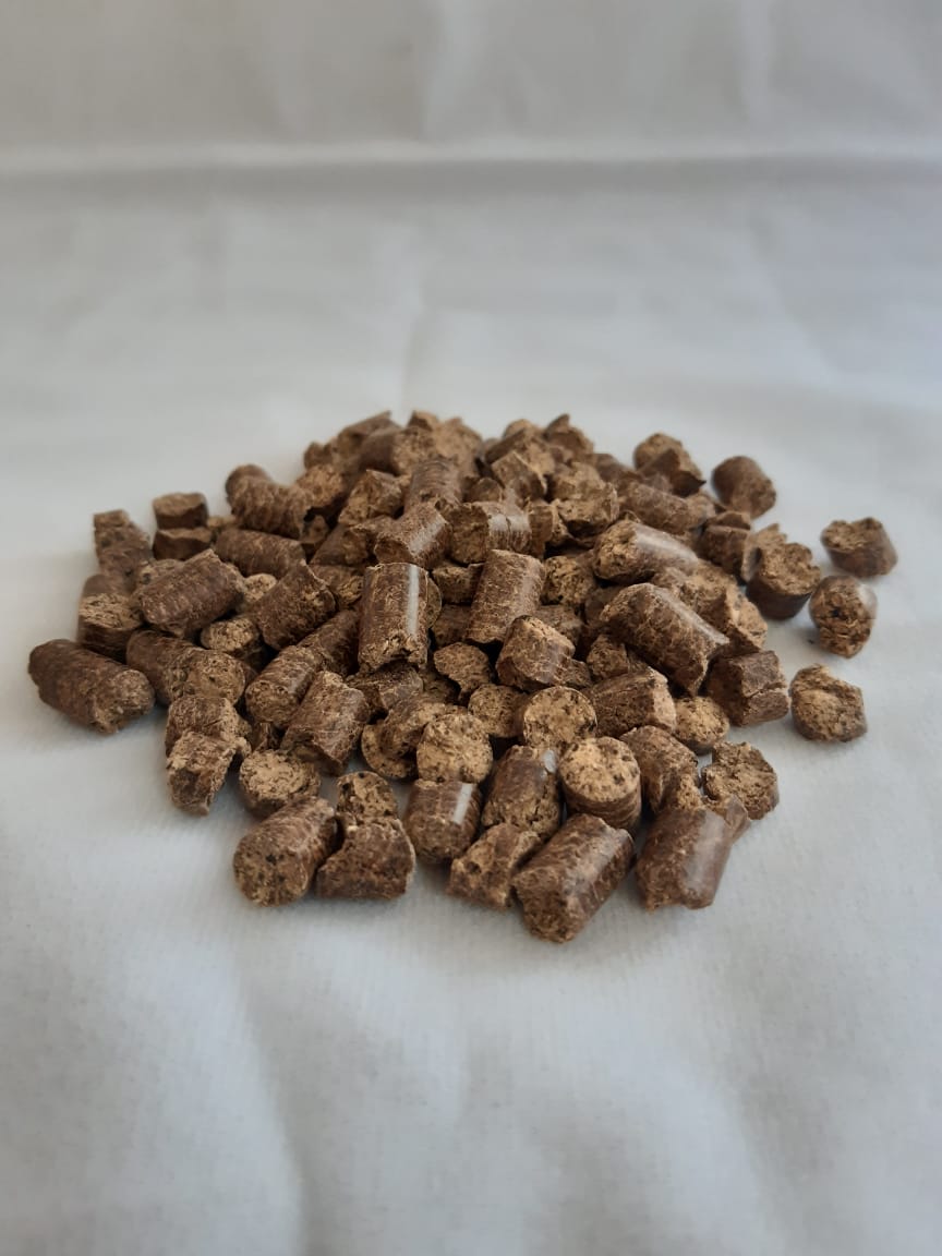 A pile of wood pellets is sitting on a white surface.