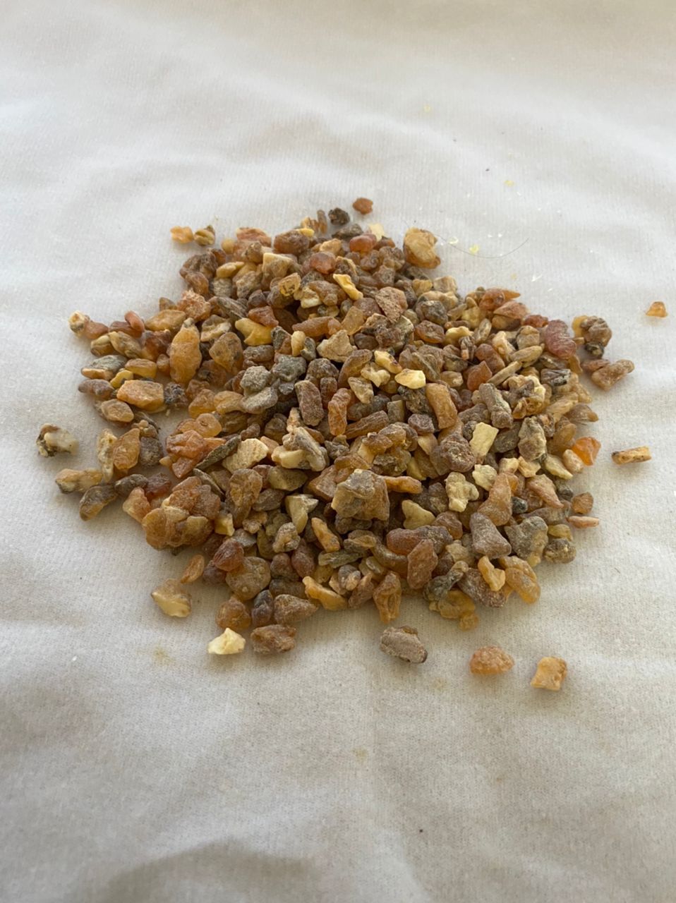 A pile of small rocks is sitting on a white cloth.
