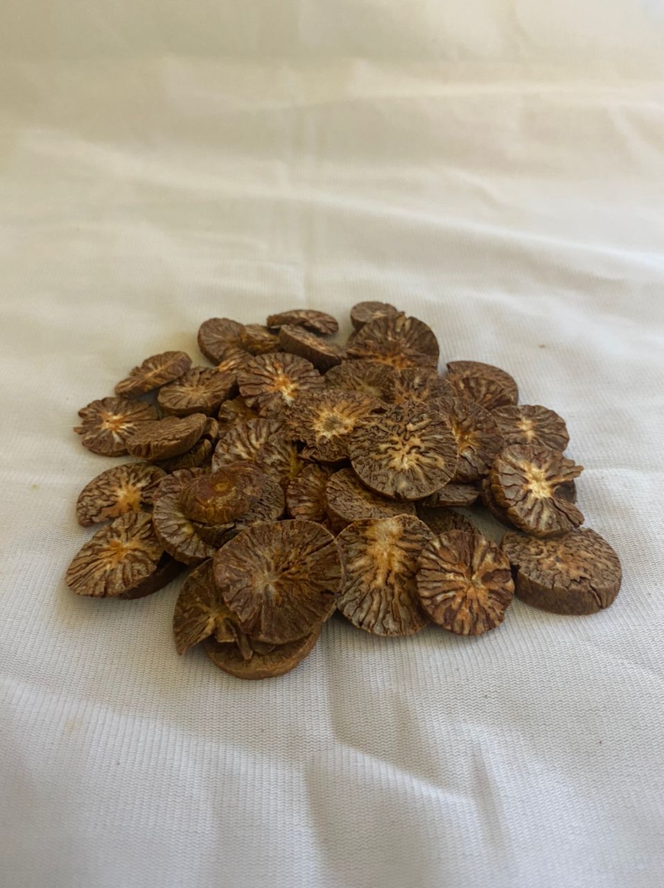 A pile of sliced betel nuts on a white cloth.