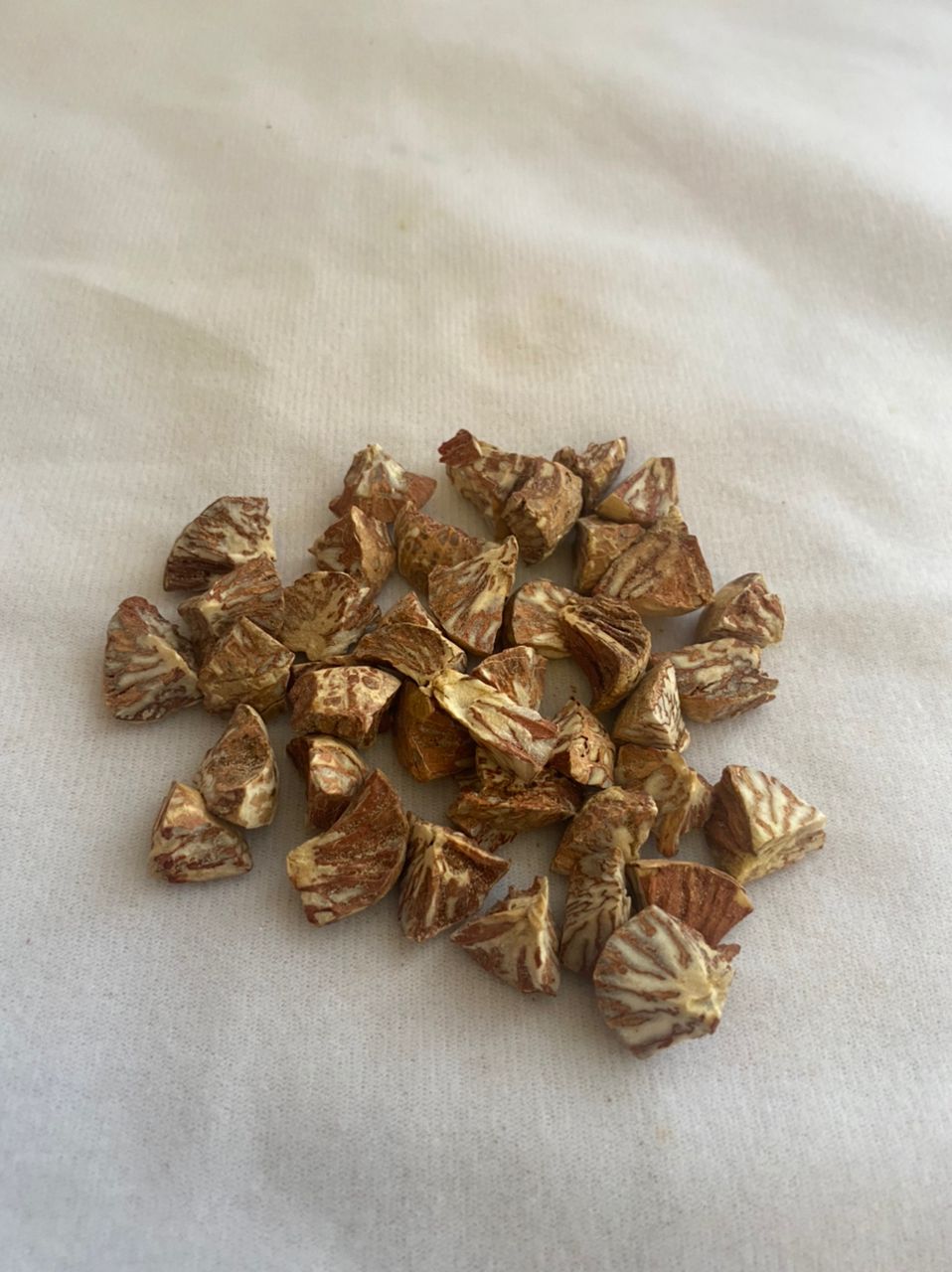 A pile of nuts is sitting on a white surface.