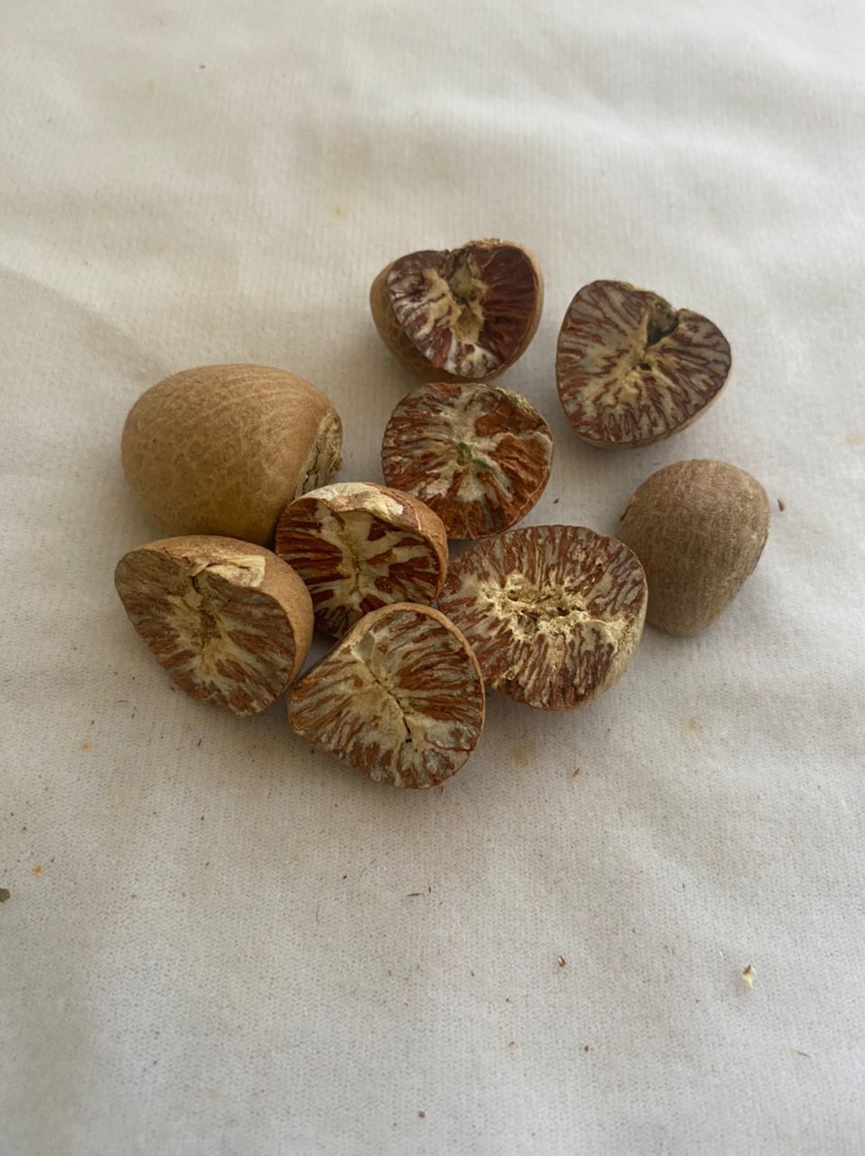 A pile of betel nuts cut in half on a white surface.