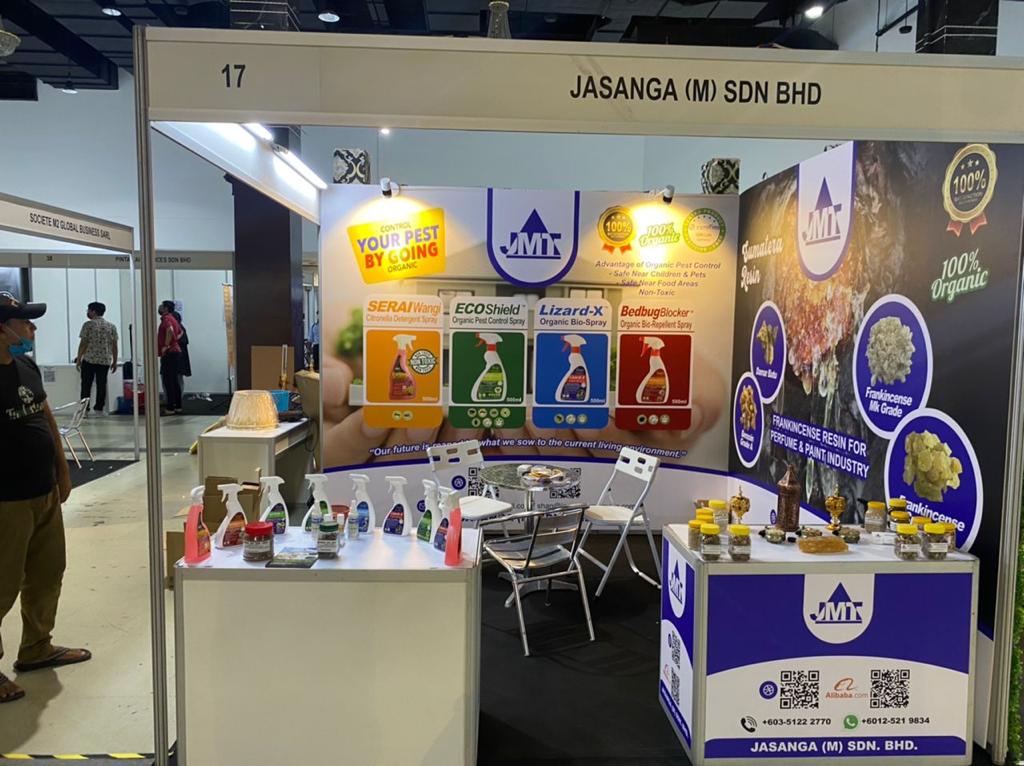 A man is standing in front of a booth at a convention.