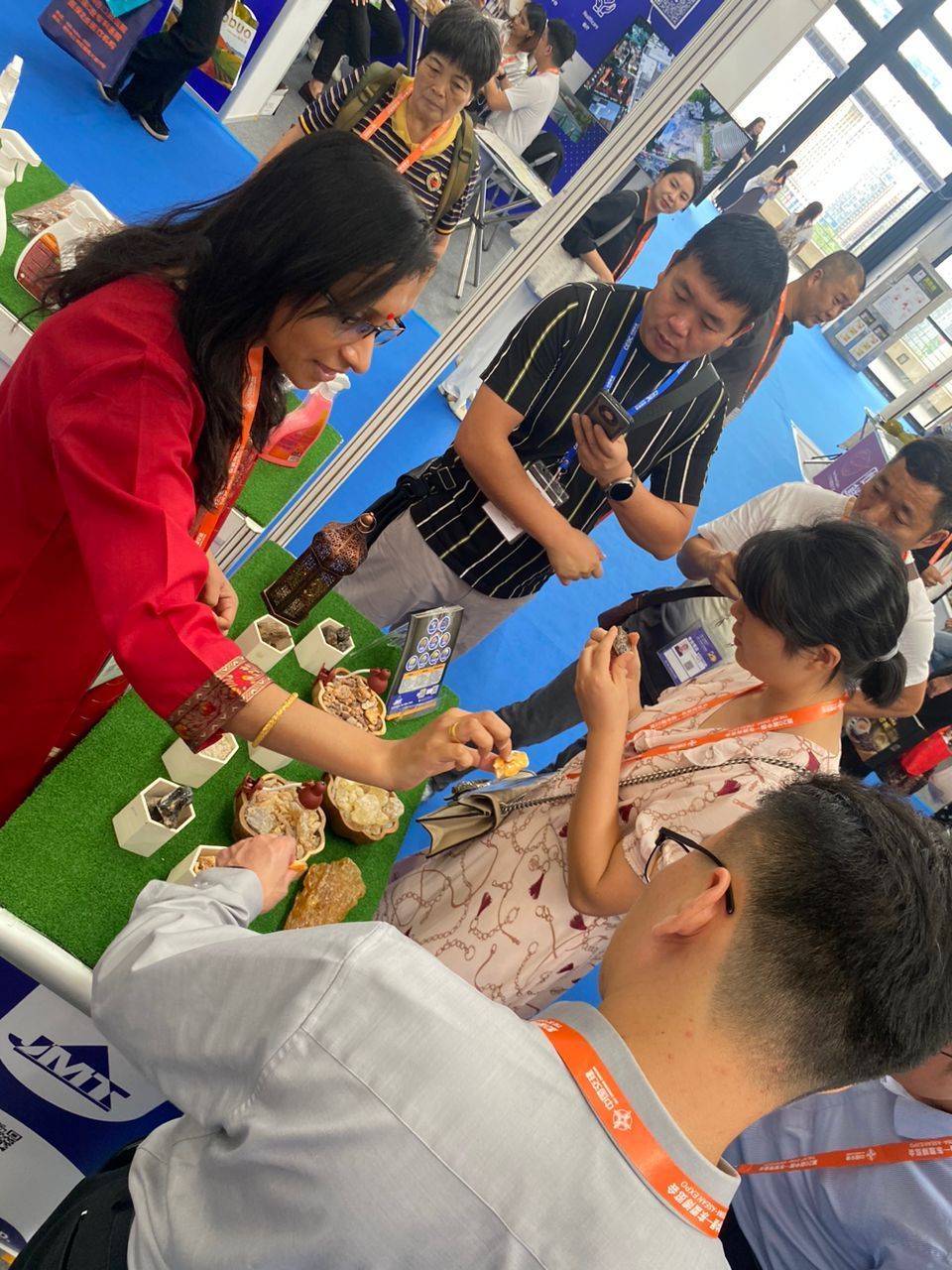 A group of people are standing around a table eating food.