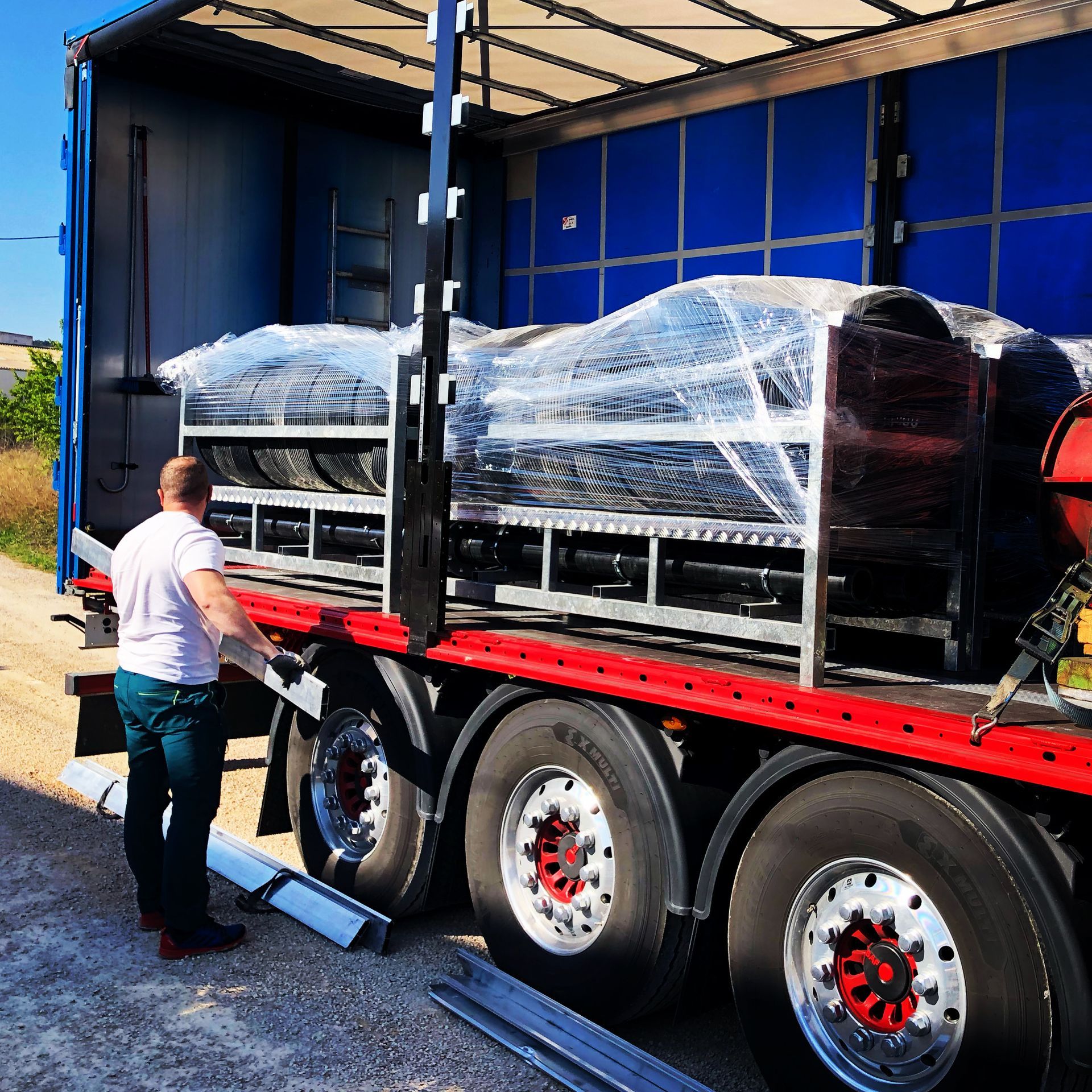 Un hombre con camisa blanca está cargando un camión grande.