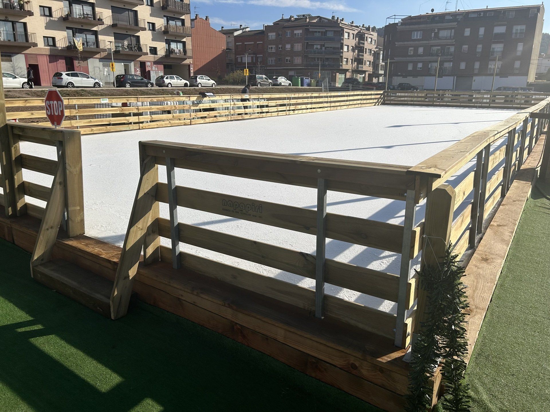 Una valla de madera rodea una pista de hielo en un parque.