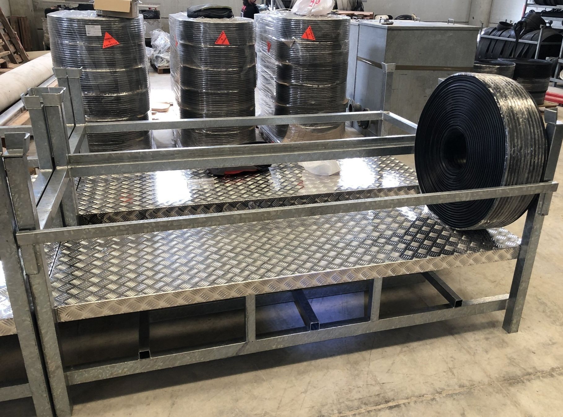 Un estante de metal con rollos de neumáticos encima en un almacén.