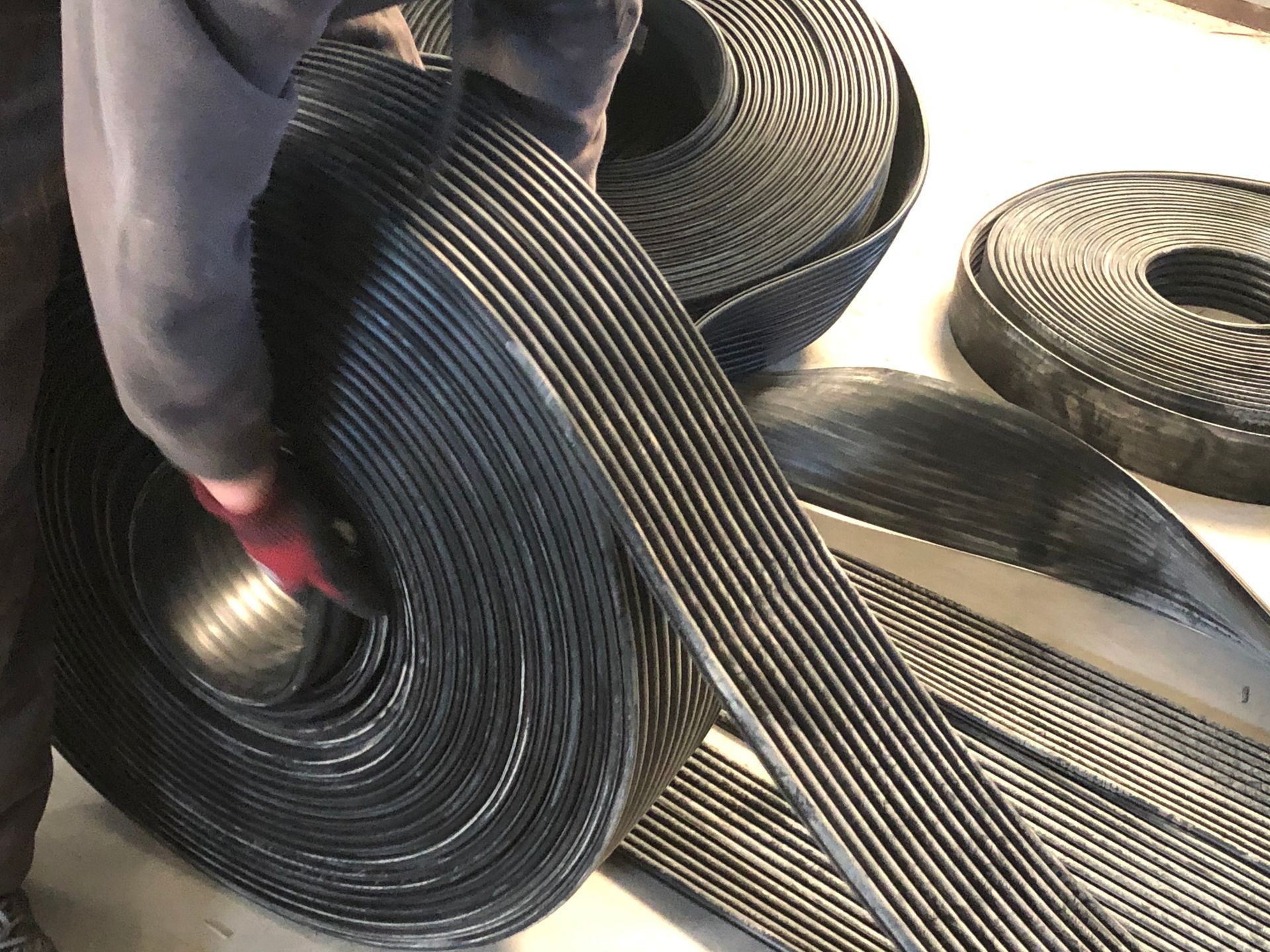 Una persona sostiene un rollo de caucho sobre una mesa.