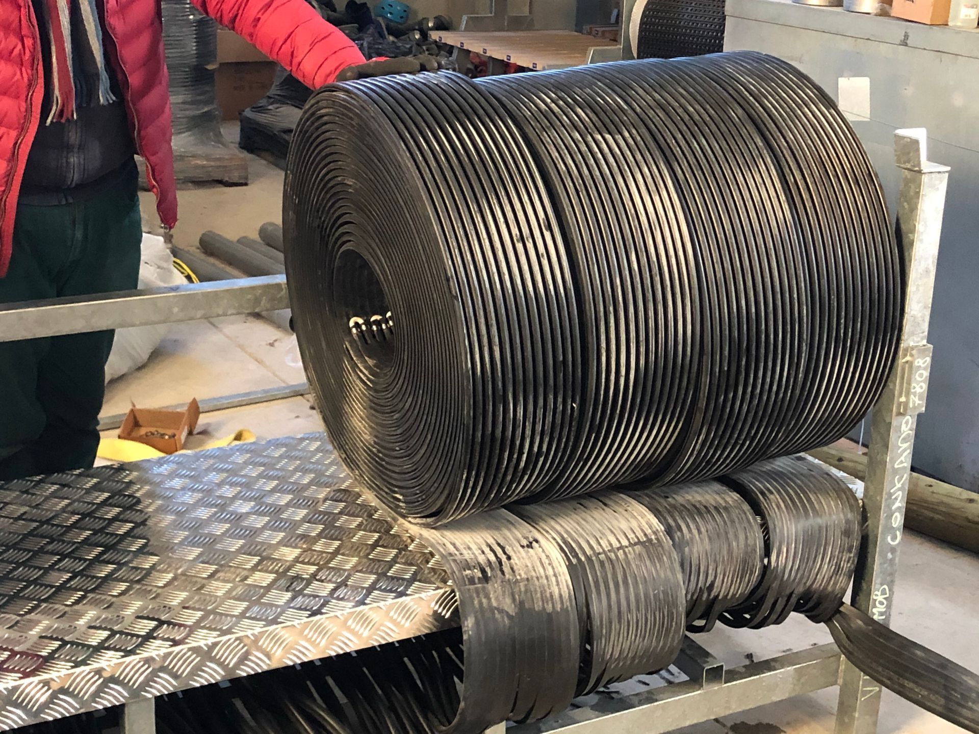 Una gran bobina de alambre se encuentra encima de una bandeja de metal.