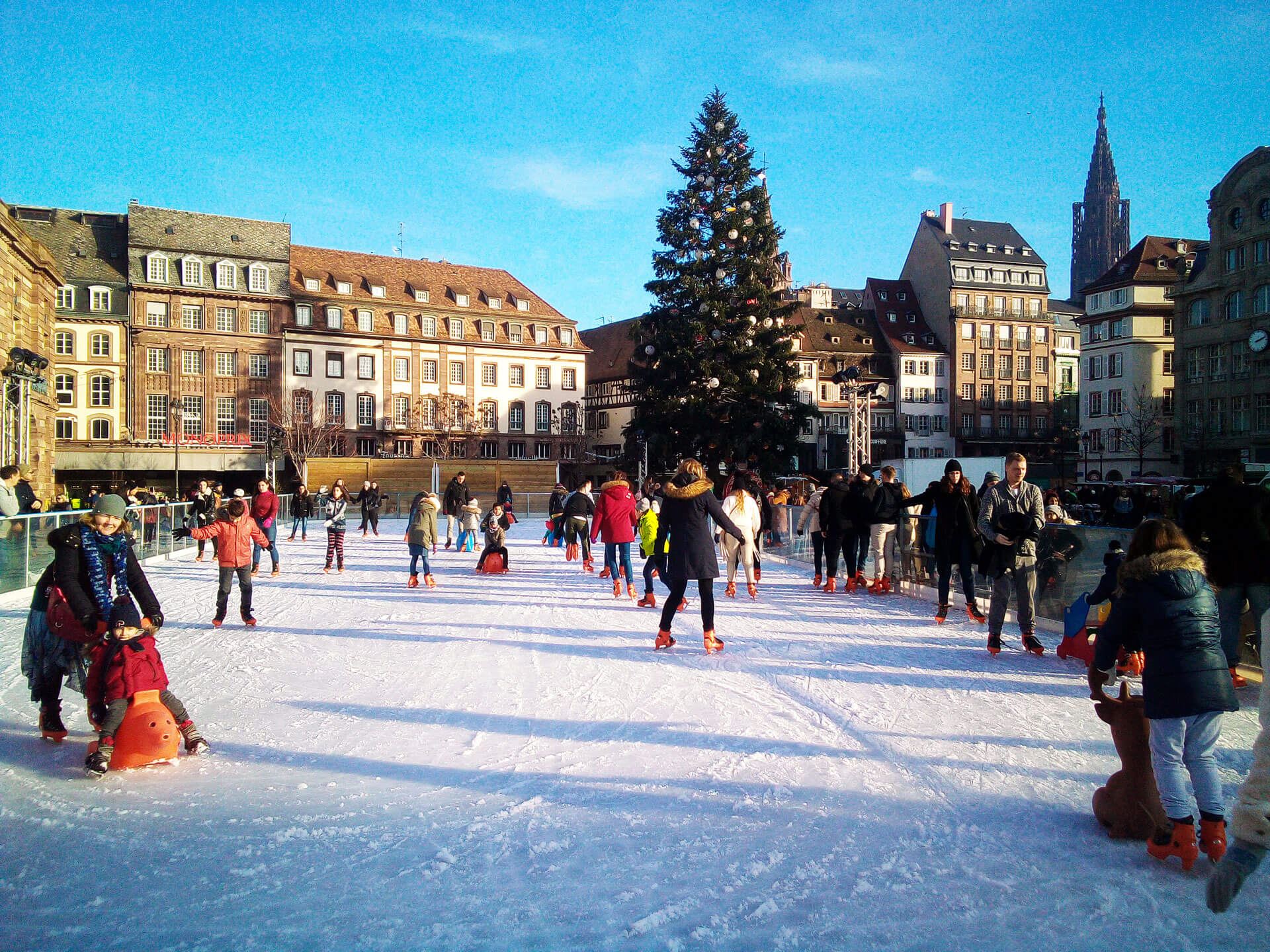 Pista de hielo urbano al aire libre con familias patinando