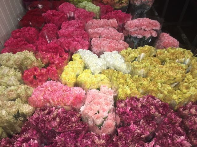 Un mazzo di fiori di diversi colori sono disposti uno sopra l'altro.