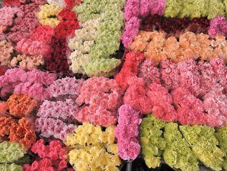 Un mazzo di fiori di diversi colori è disposto uno sopra l'altro su un tavolo.
