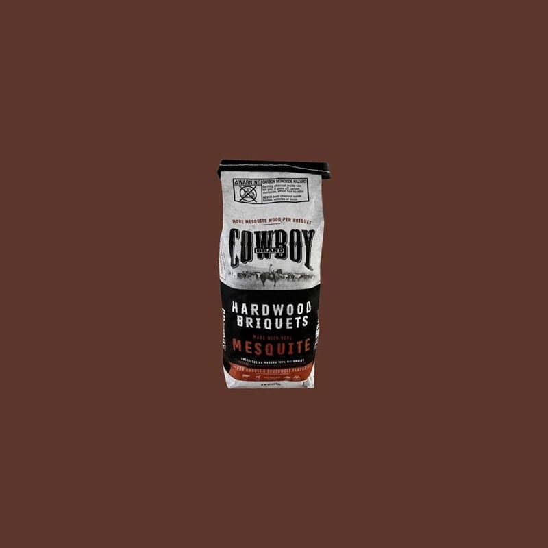 Bag of Cowboy hardwood mesquite briquets on a dark brown background.