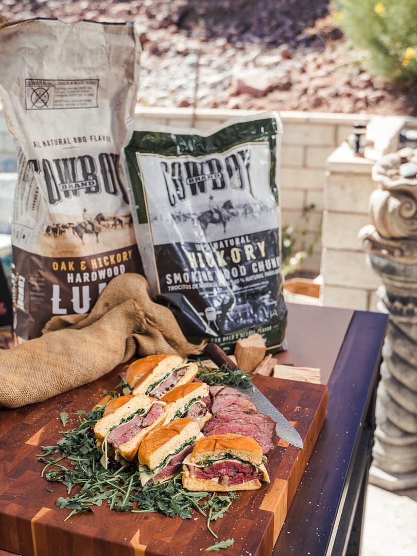 Tri-tip sandwiches with bags of Cowboy Lump and Hickory chunks in background
