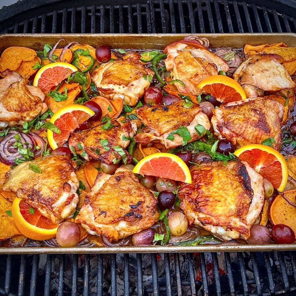 Roasted chicken thighs in a sheet pan with roasted sweet potatoes and grapes