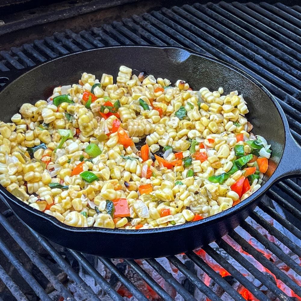 Corn and peppers for the Best Ever Smoked Cornbread recipe, cooking in cast iron skillet on the grill