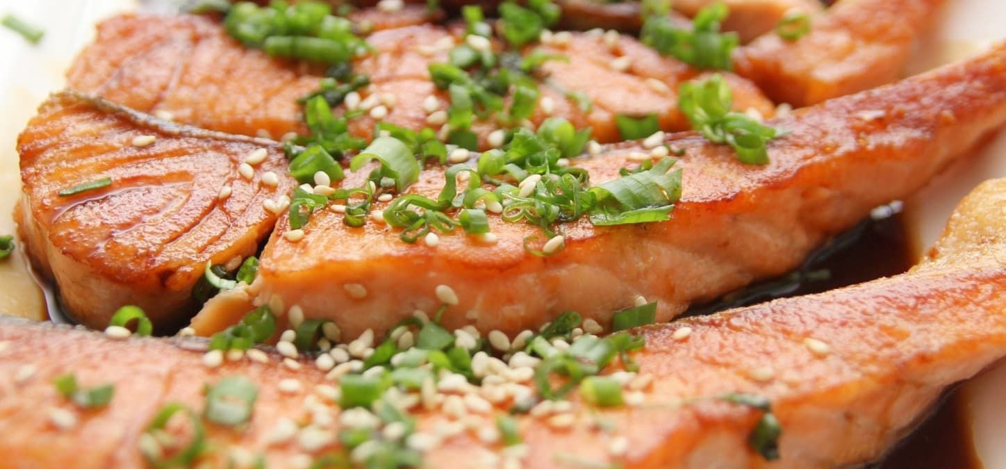 brown sugar bourbon glazed salmon topped with scallions and sesame seeds