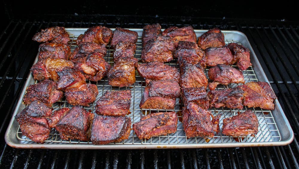 beef chuck roast burnt ends smoking on pan in grill