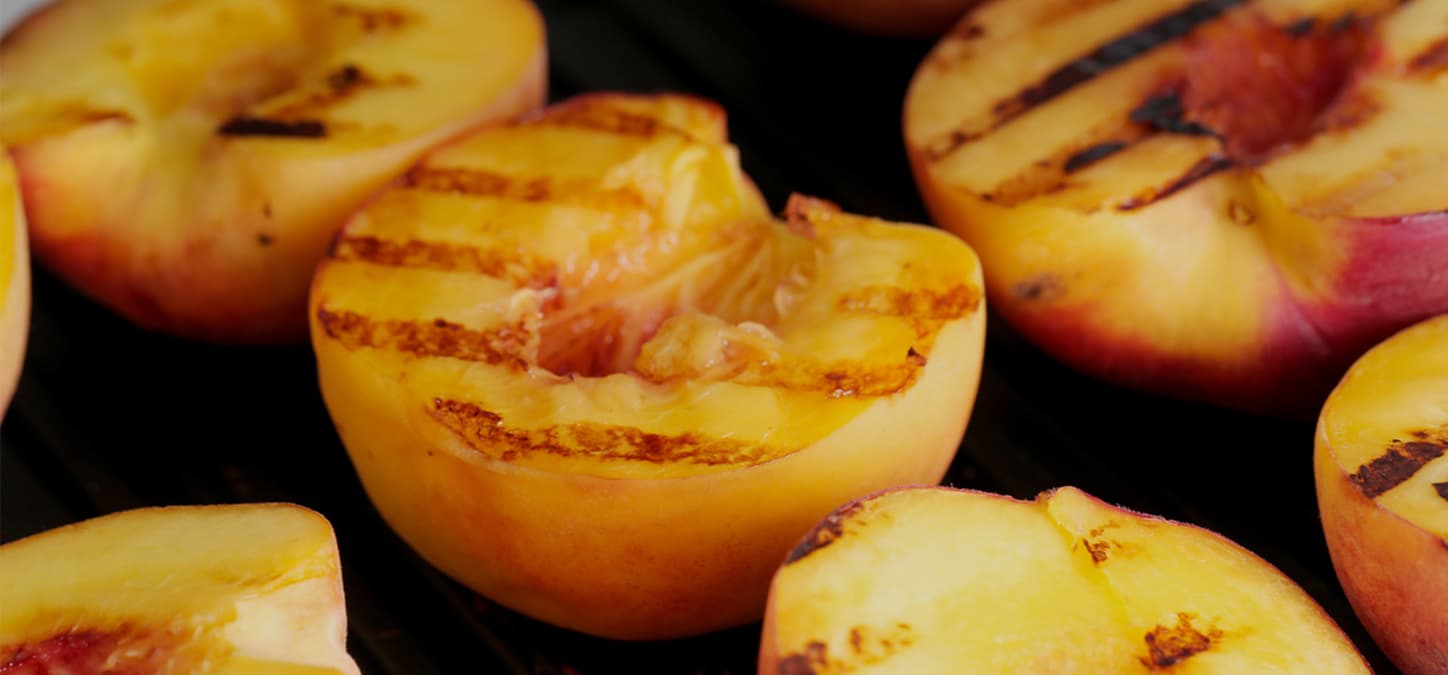 closeup of grilled peach halves face up