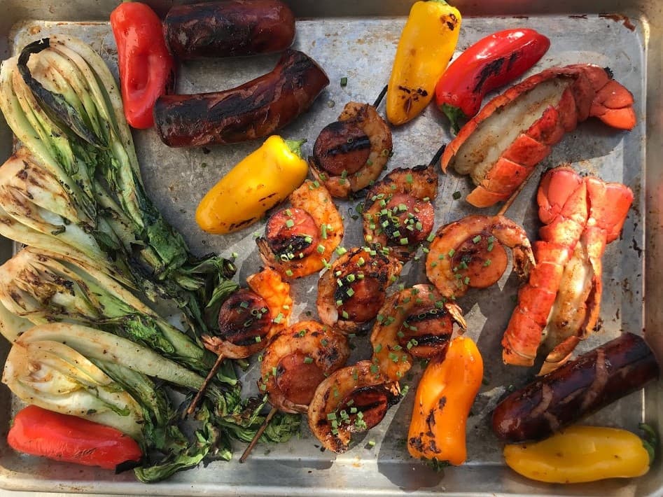 Grilled lobster tails with shrimp and sausage skewers
