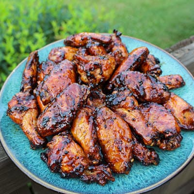 grilled maple peach sticky wings on a plate