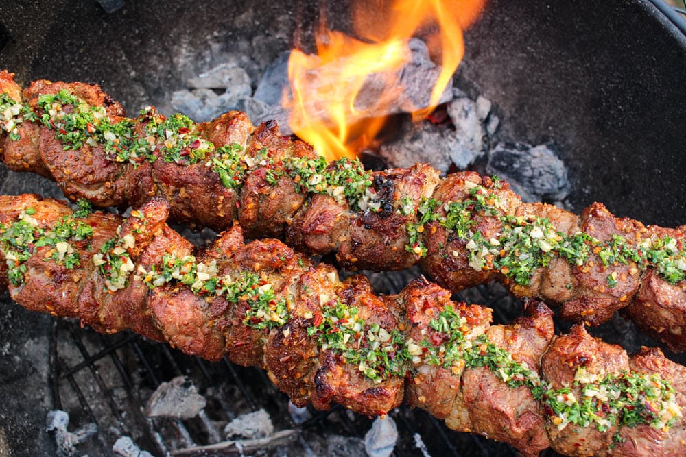 Spiced lamb kebabs with mint chimichurri cooking on the grill