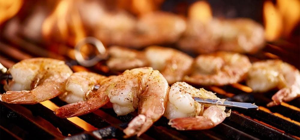Shrimp on skewers cooking on the grill