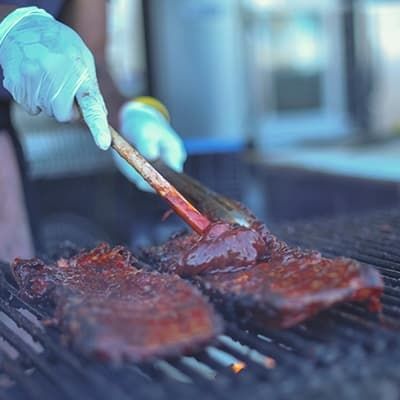 meat on the grill smothered in bbq sauce