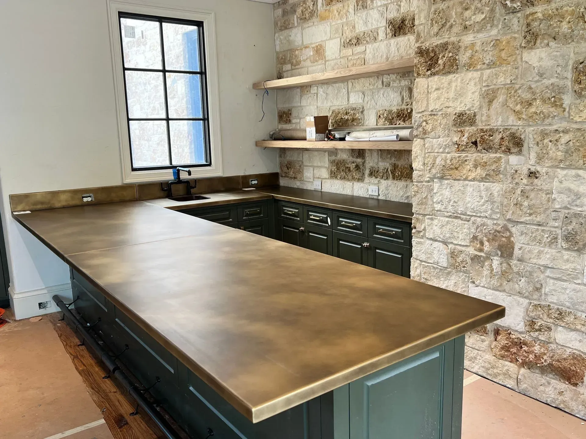 A kitchen with a large counter top and a brick wall.