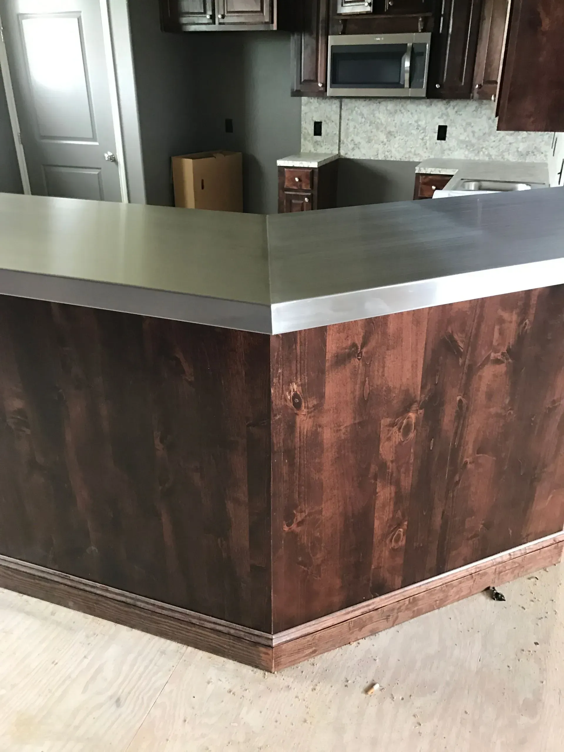 A kitchen with a wooden counter top and a stainless steel counter top