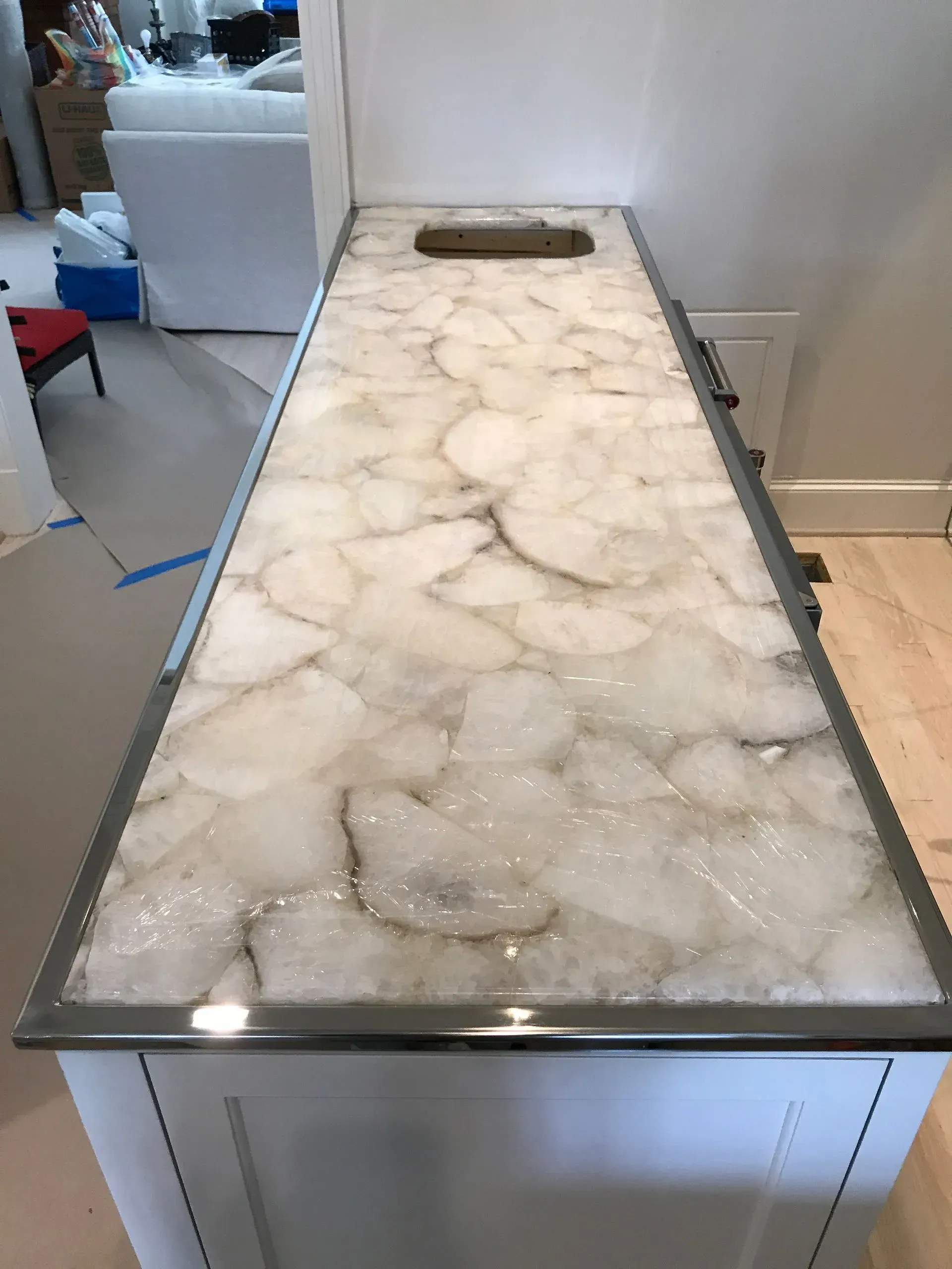A kitchen counter with a marble counter top and a sink.