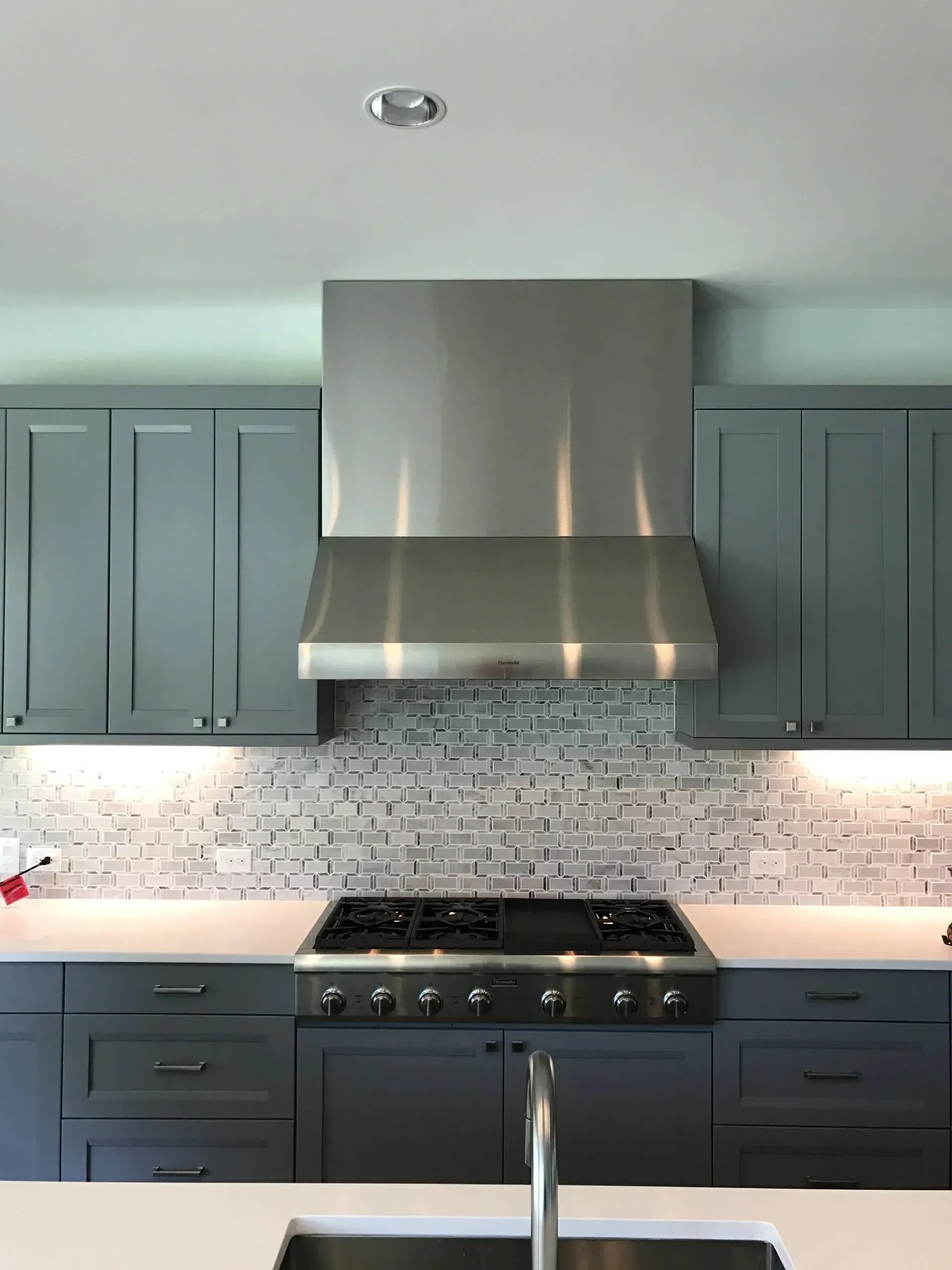 A kitchen with a stove top oven and a sink