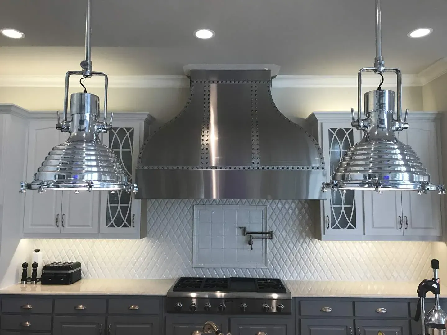 A kitchen with stainless steel appliances and gray cabinets