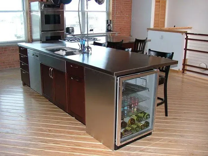 A kitchen with a stainless steel island and a wine cooler