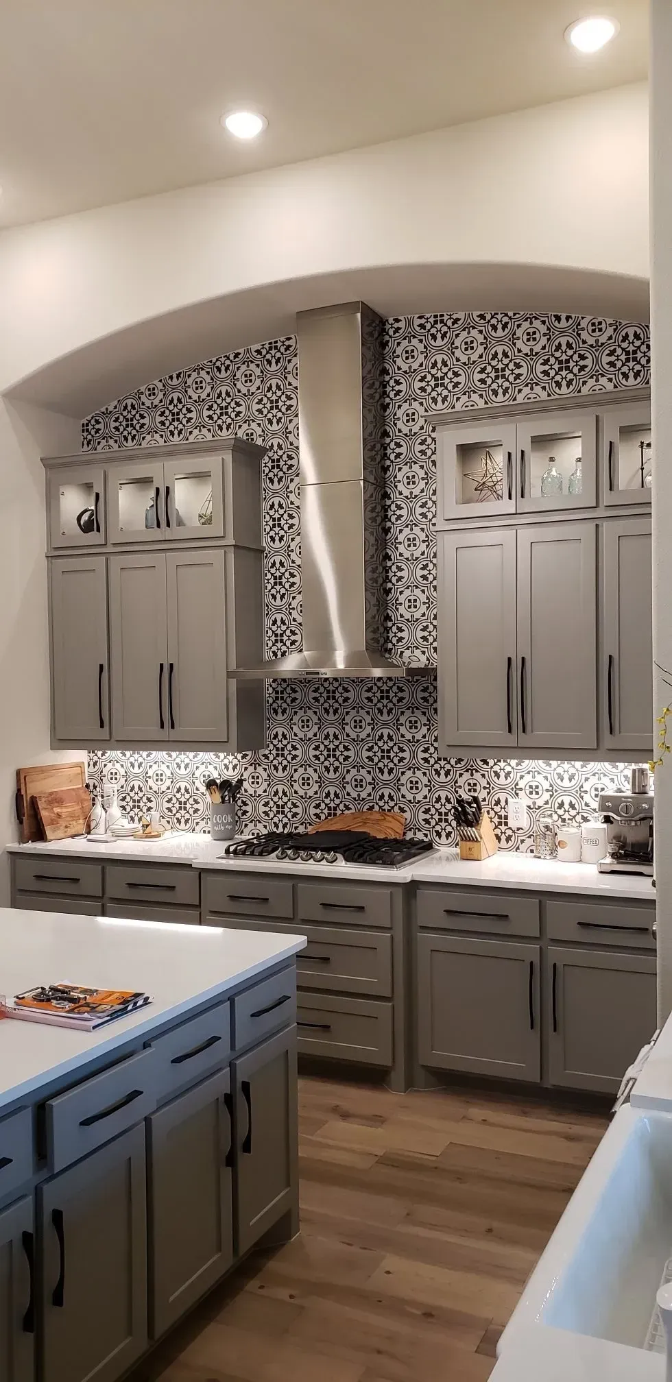A kitchen with gray cabinets and stainless steel appliances.