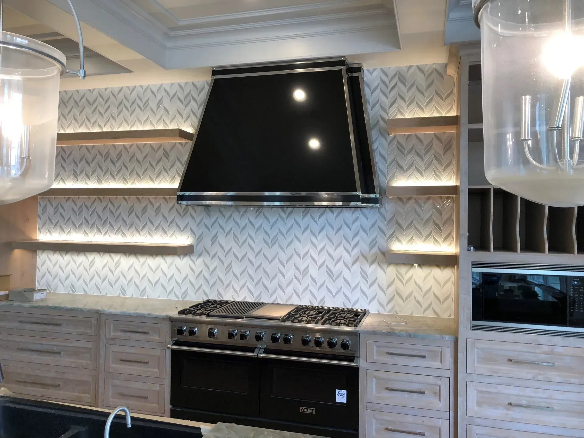 A kitchen with a black stove top oven and a black hood