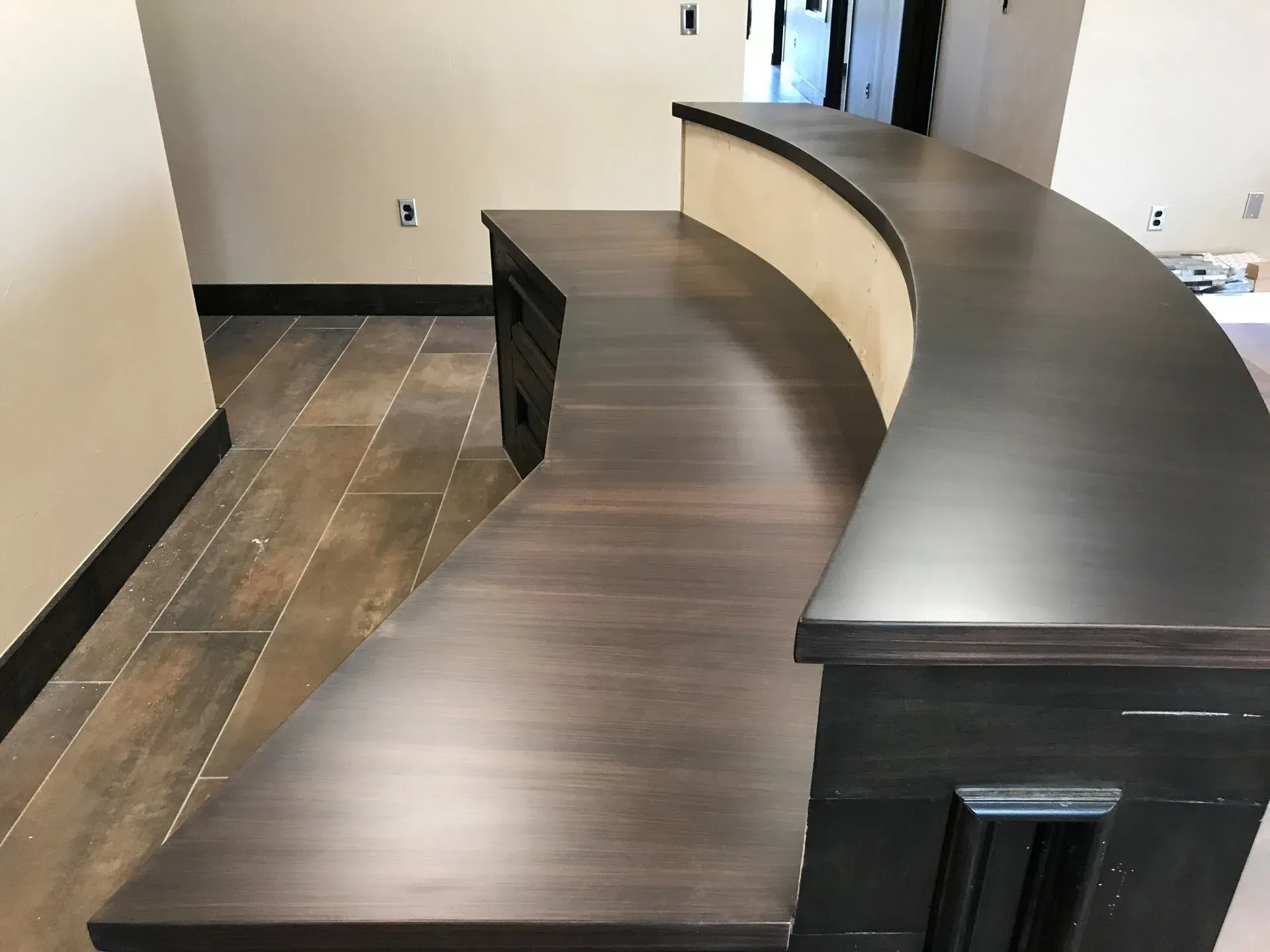 A curved desk in a room with a tiled floor