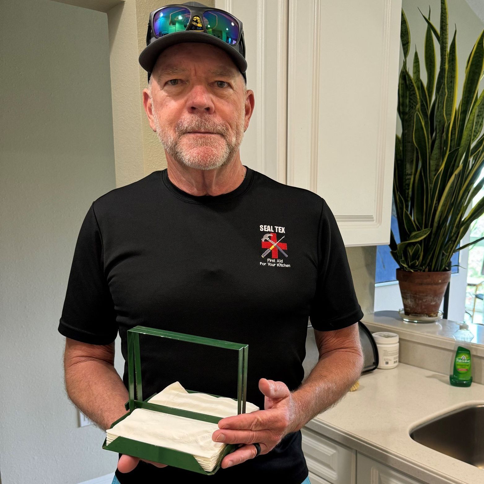 A man in a black shirt is holding a napkin holder