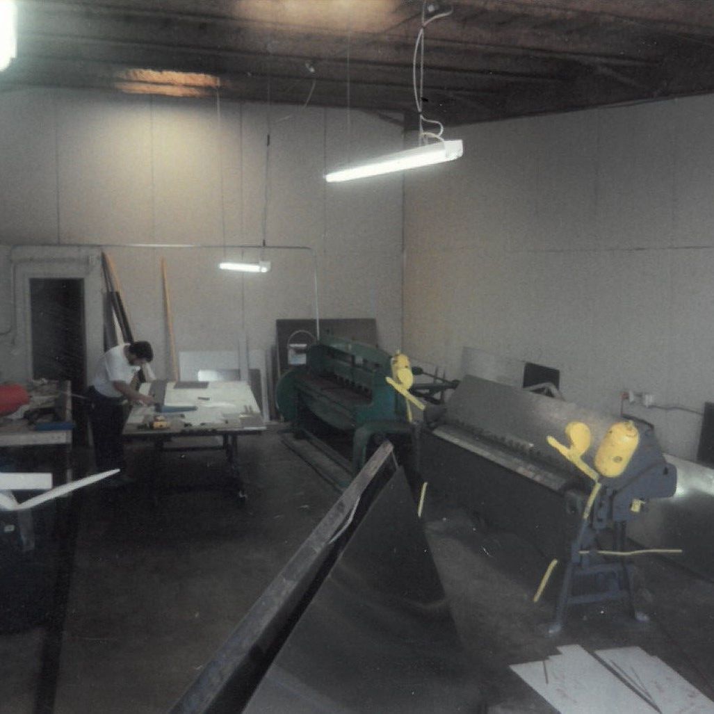 A man is working in a room with a machine that has the letter e on it