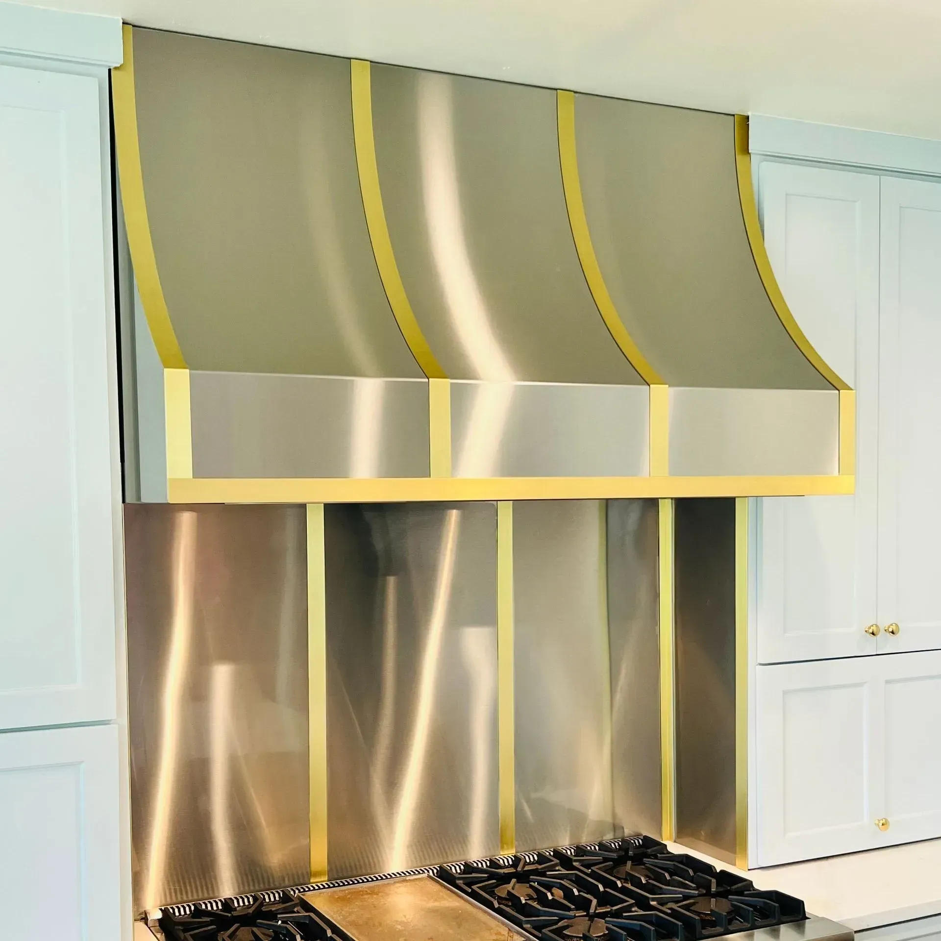 A stove with a stainless steel hood above it