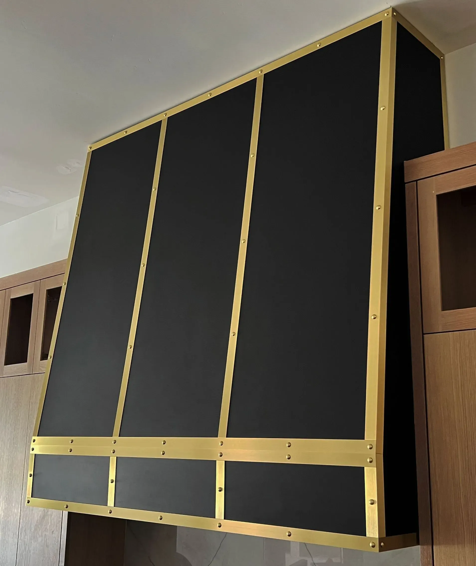 A black cabinet with gold trim is hanging from the ceiling