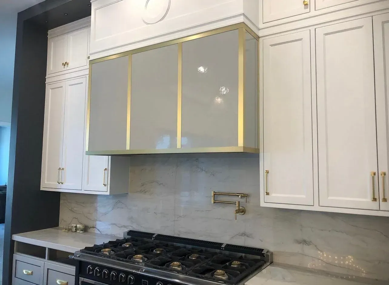 A kitchen with white cabinets and a stove top oven.