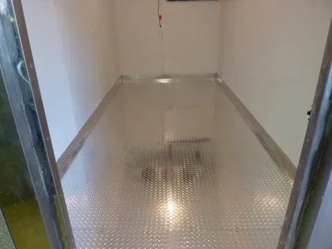 A room with a metal floor and white walls.