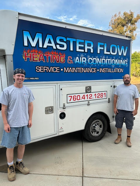 Two men stand by a white service truck with