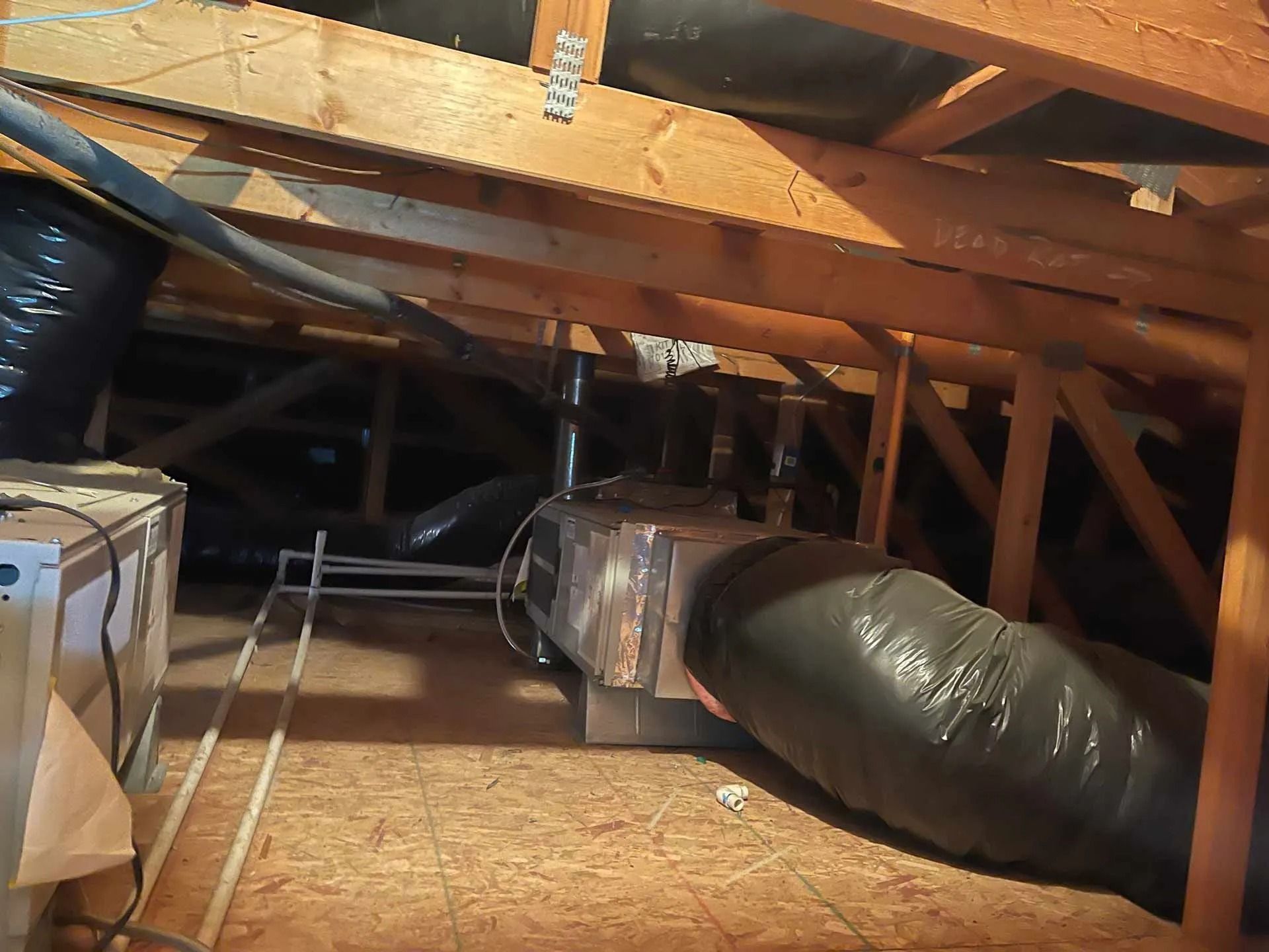 An attic with a large black pipe going through it