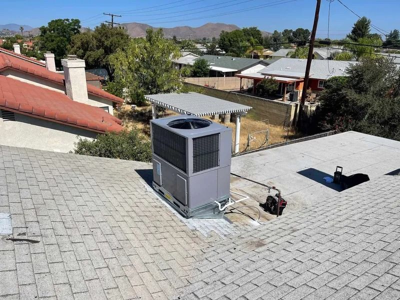 A large air conditioner is sitting on top of a roof.