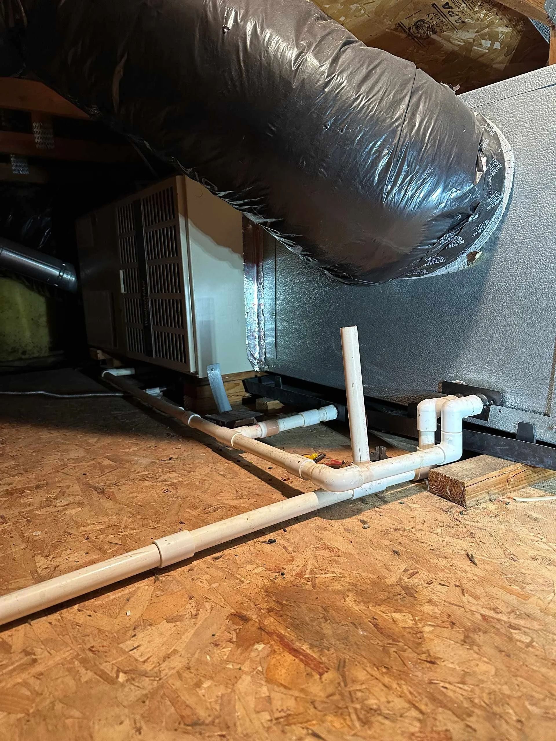 There is a pipe coming out of the ceiling of a room.