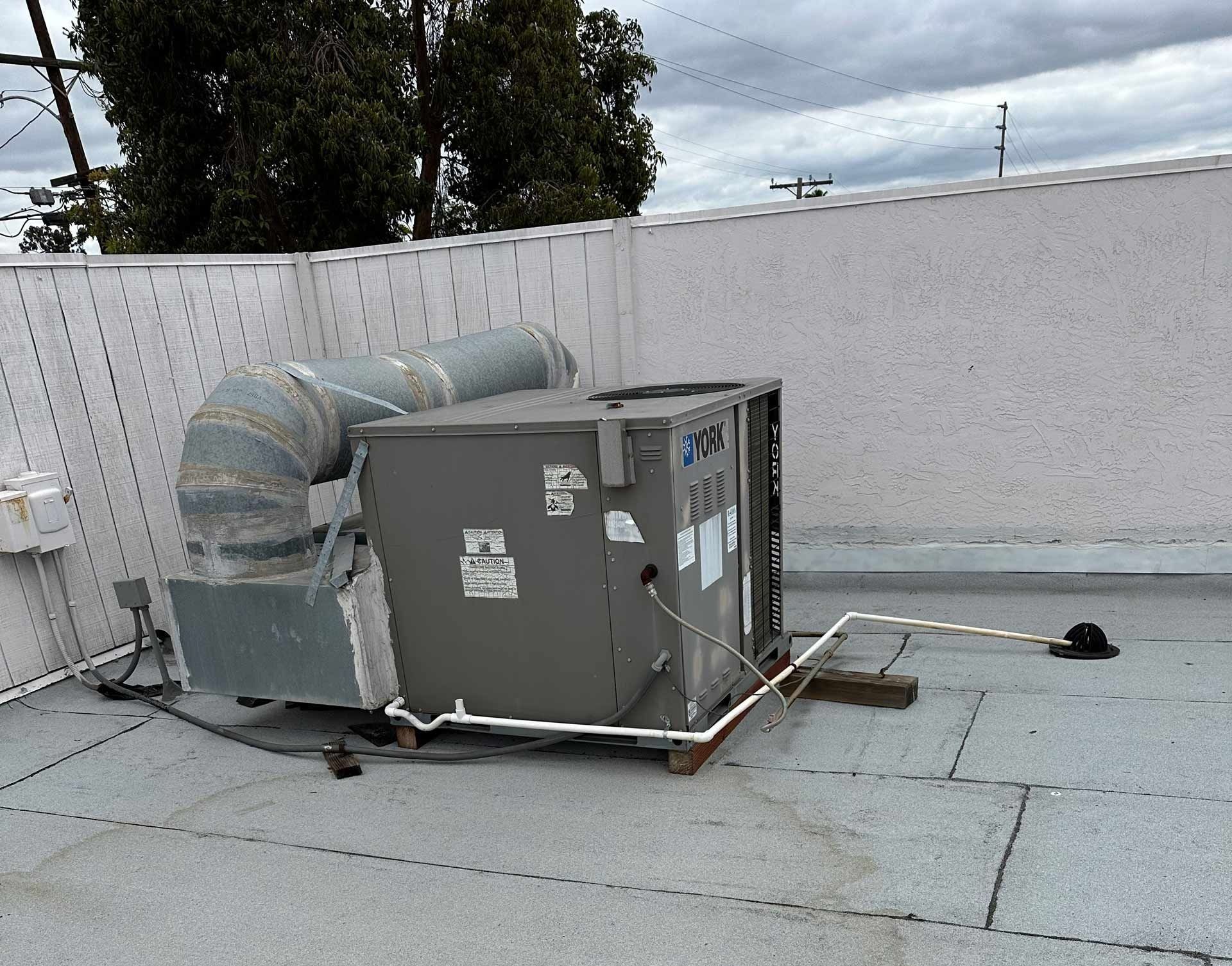 An air conditioner is sitting on the roof of a building.